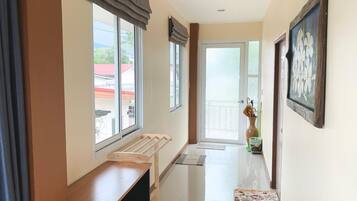 A hallway with a bench, a door with frosted glass, and a framed picture on the wall.