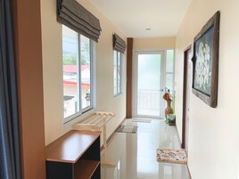 A hallway with a bench, a door with frosted glass, and a framed picture on the wall.
