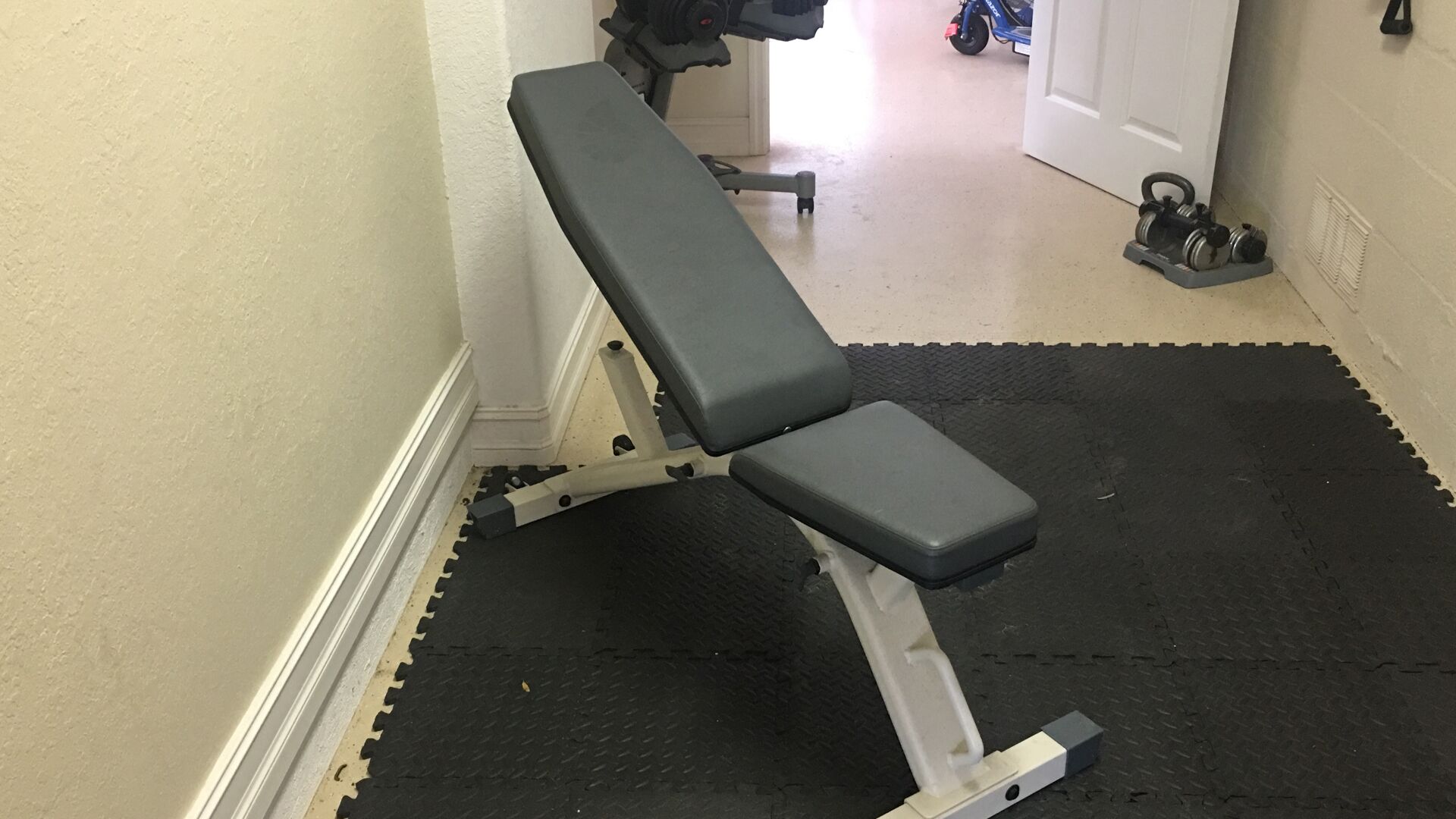 Et fitnessrum med bænk og vægte.