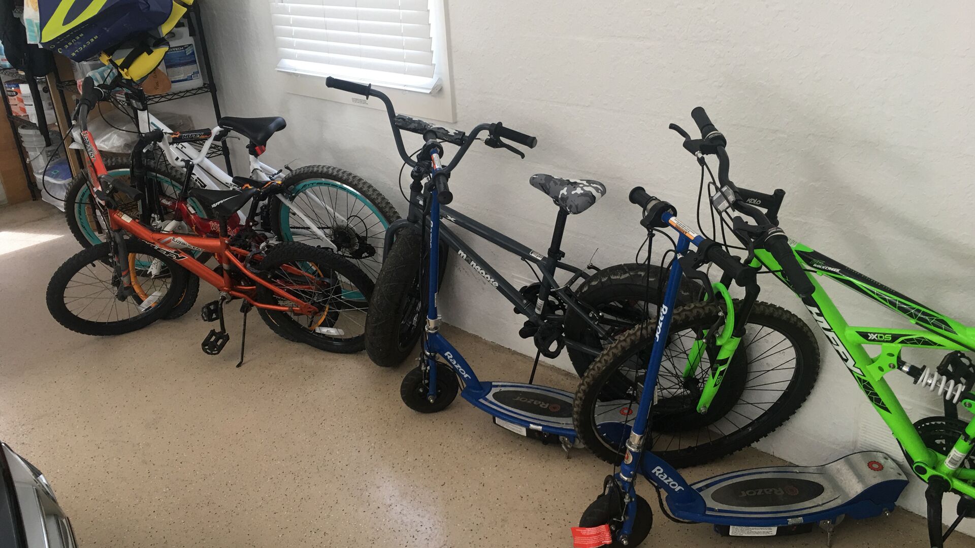 Cykler op ad en væg i et rum med betongulv.