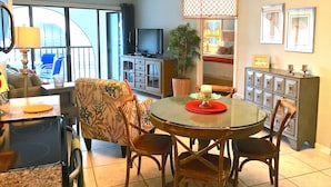 A dining area with a round table, chairs, a television, and a potted plant. - PARADISE-Anglers Cove Waterfront Designer Condo (Marco Island)