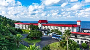 Un grand hôtel aux toits rouges, composé de plusieurs bâtiments et offrant une vue sur l’océan.