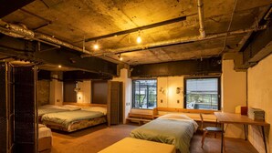 A room with two beds, a desk, and a window with a view. - Kagoshima Guest House M104 - Hostel (Kagoshima)