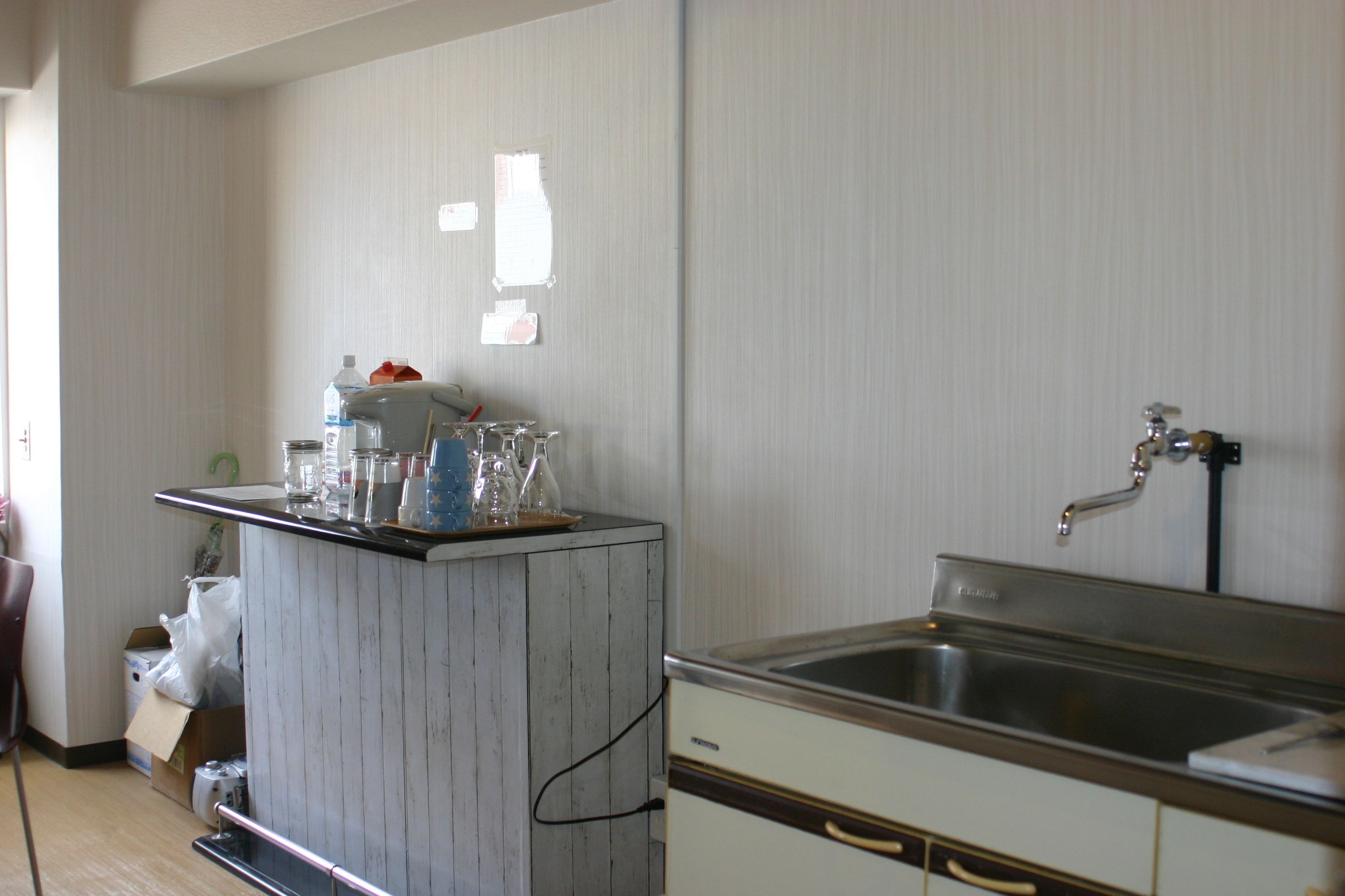 A kitchen with a wooden island, stainless steel sink, and cabinets.