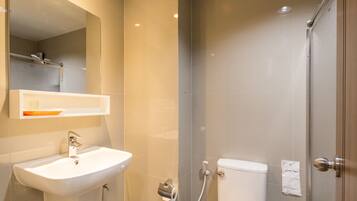 A modern bathroom with a sink, mirror, and toilet.