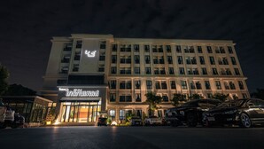 A hotel with a modern facade, multiple floors, and a well-lit entrance. - Glai Gan Place Hotel (Saraburi)