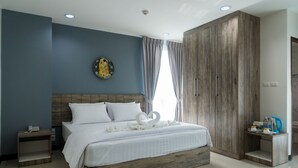 A modern bedroom with a large bed, wooden headboard, a nightstand, a wardrobe, and a decorative wall piece. - Glai Gan Place Hotel (Saraburi)