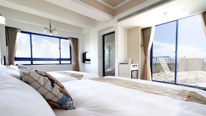 Une chambre d’hôtel avec un grand lit, un bureau et une vue sur le balcon.