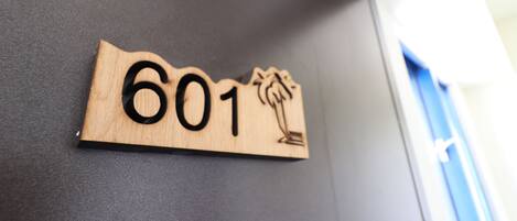 A wooden sign with the number 601 on a dark wall.