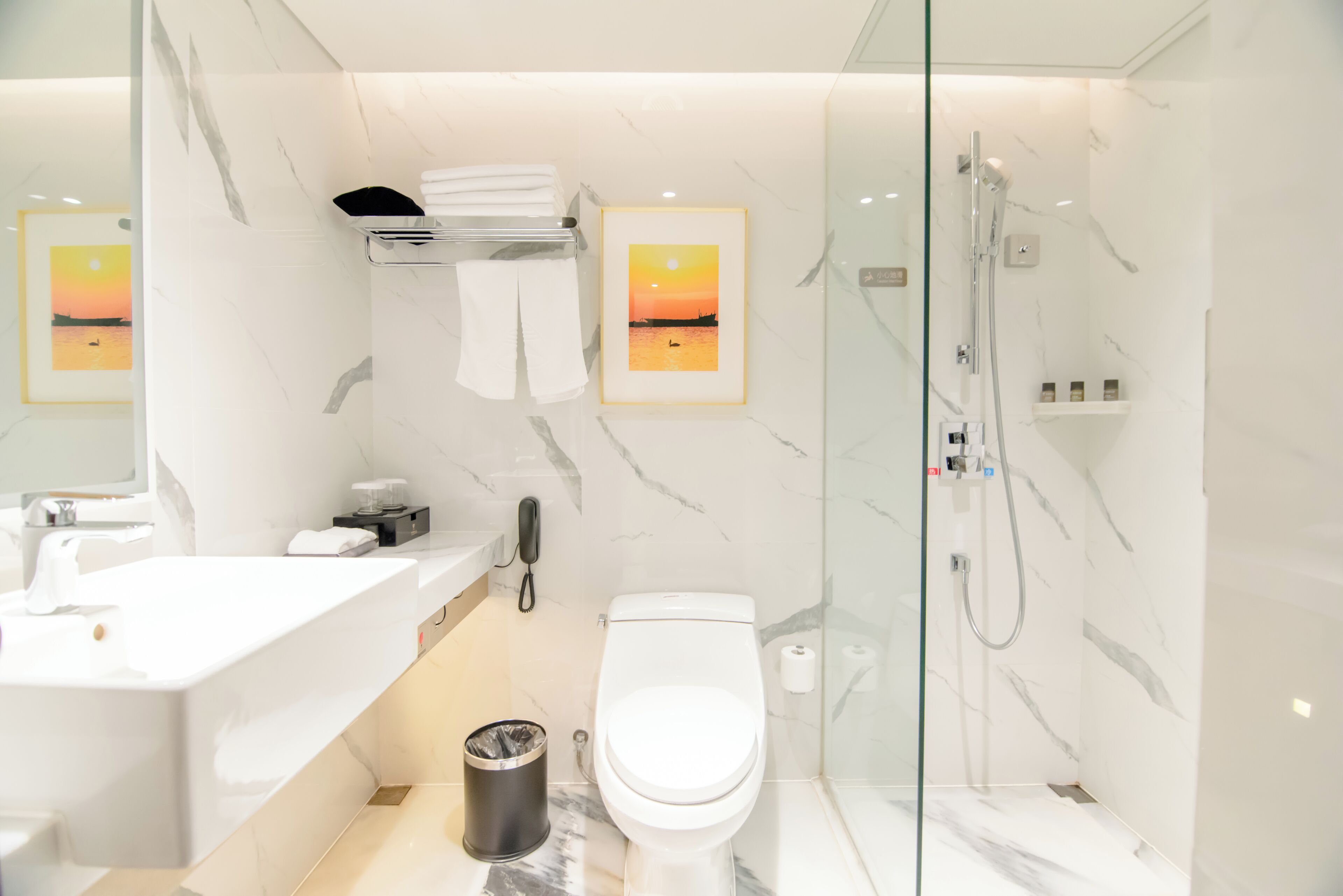 A modern bathroom with a toilet, sink, and shower.