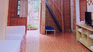 Interior de madera con una escalera, una cama y una estantería con toallas.