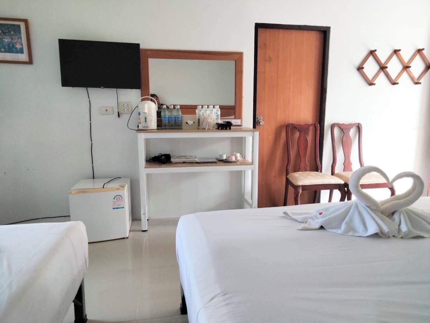 Una habitación de hotel con una cama, un escritorio, una silla, un televisor y un armario.