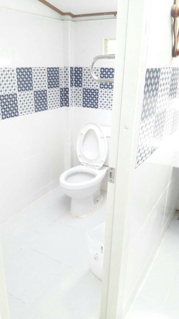 A bathroom with a toilet, tiled walls, and a shower area.