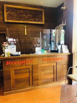 A reception desk with 'Reception' and 'Information' labels, a security camera, and a decorative wall piece above. - Phurua Bussaba Resort & Spa (Phu Ruea)