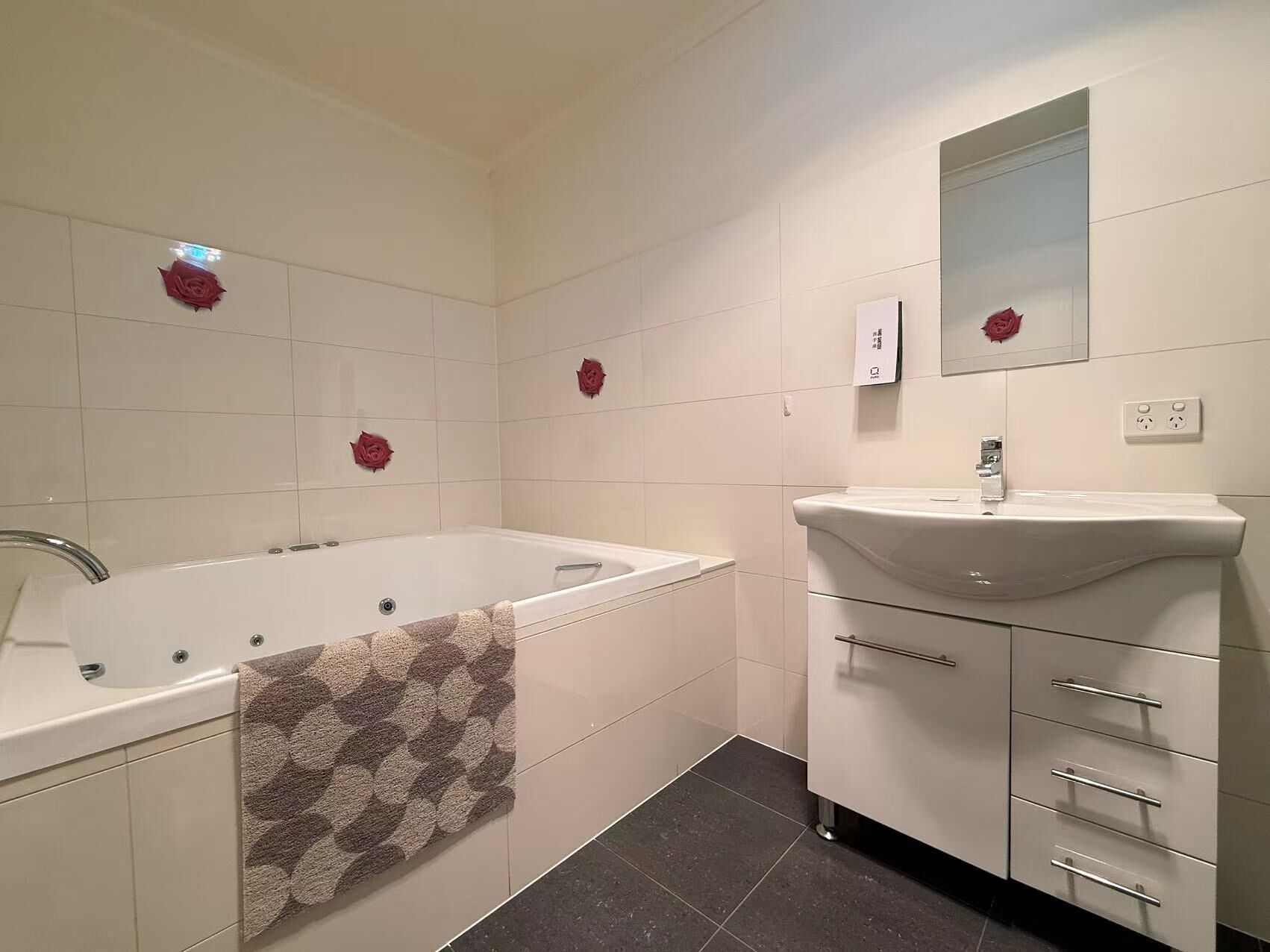 Un baño moderno con bañera, lavamanos y espejo.