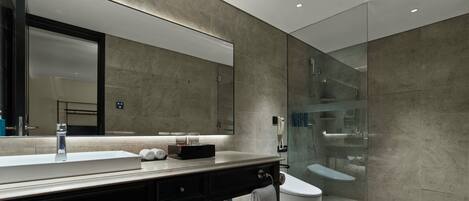 Un bagno moderno con uno specchio grande, un lavabo, un water e una cabina doccia in vetro.