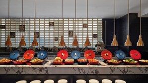 A buffet setup with multiple dishes and a marble countertop.