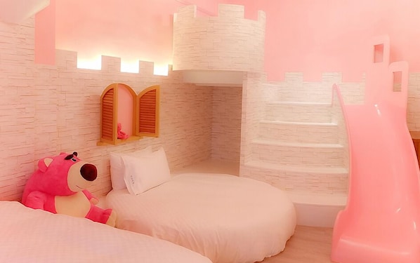 A children's bedroom with a castle-themed design, including a slide and a bed with a plush toy.