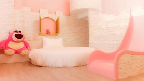 A bedroom with a bed, a pink chair, a small window with a teddy bear, and a pink slide. - Tong's Story Paternity B&B (Hualien City)