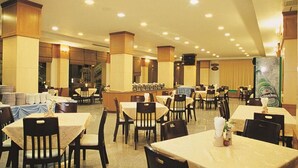 A spacious restaurant with multiple tables and chairs, a bar area, and a large Heineken advertisement. - Westerngrand Hotel Ratchaburi (Ratchaburi)
