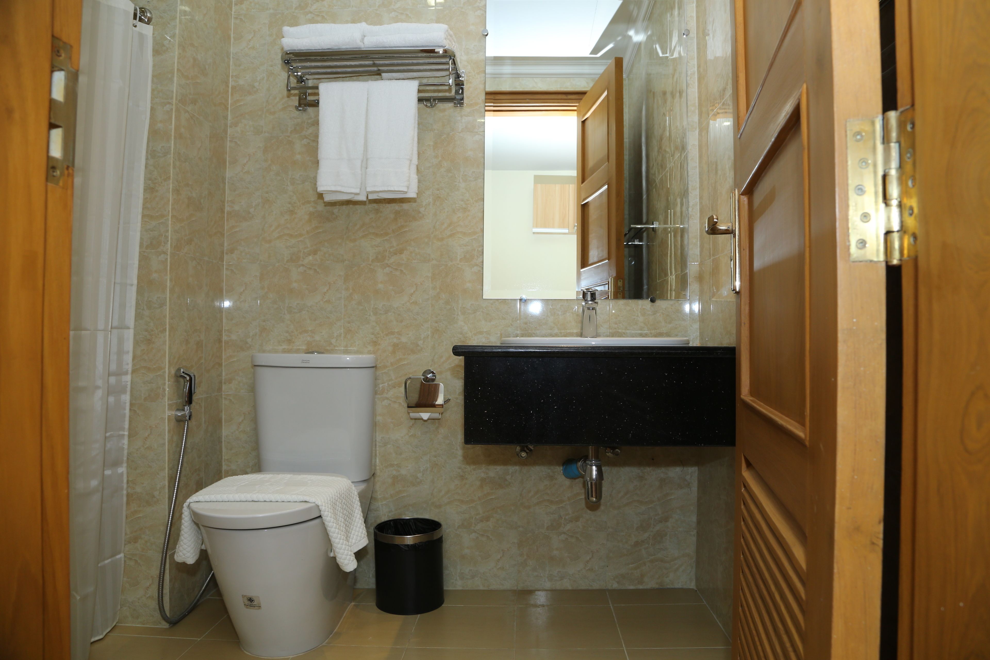 Un baño con inodoro, lavamanos, espejo y ducha.