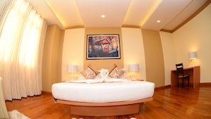 Une chambre spacieuse avec un grand lit, un bureau et une chaise.
