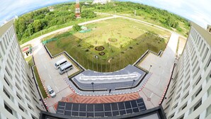 Un stade doté d’un terrain central, de tribunes pour les spectateurs et d’un parking.