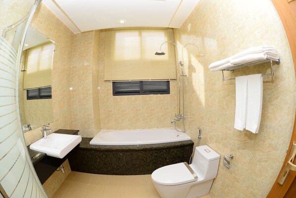 A modern bathroom with a bathtub, toilet, and sink.