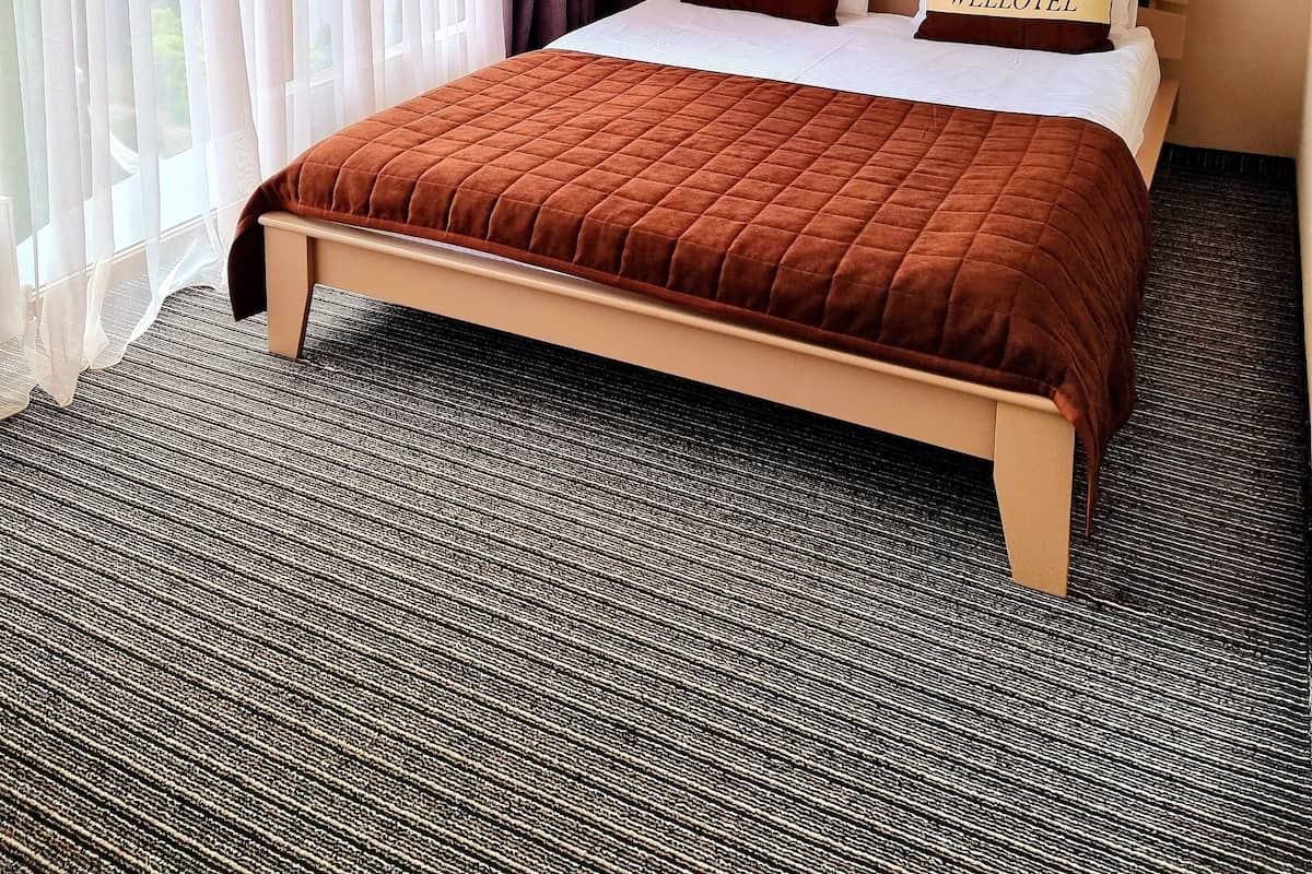 Ein Hotelzimmer mit einem großen Bett, einem Gemälde an der Wand und transparenten Vorhängen.