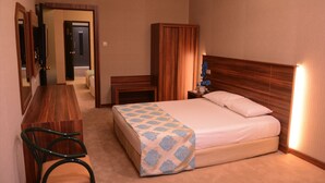 A hotel room with a bed, a wooden nightstand, a desk, and a chair. - Ayintap Hotel (Gaziantep)