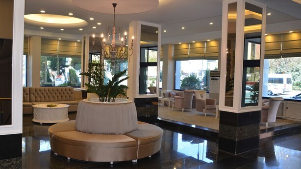 A spacious lobby with a round seating area, a chandelier, and large windows offering views of the outside. - Ayintap Hotel (Gaziantep)