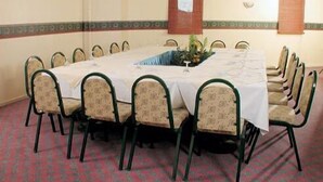 A conference room with a long table and chairs, a plant centerpiece, and patterned carpet. - Ayintap Hotel (Gaziantep)