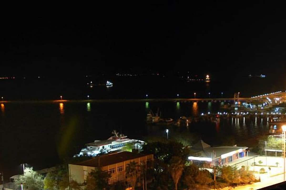 Une zone riveraine avec des bâtiments illuminés et un quai.