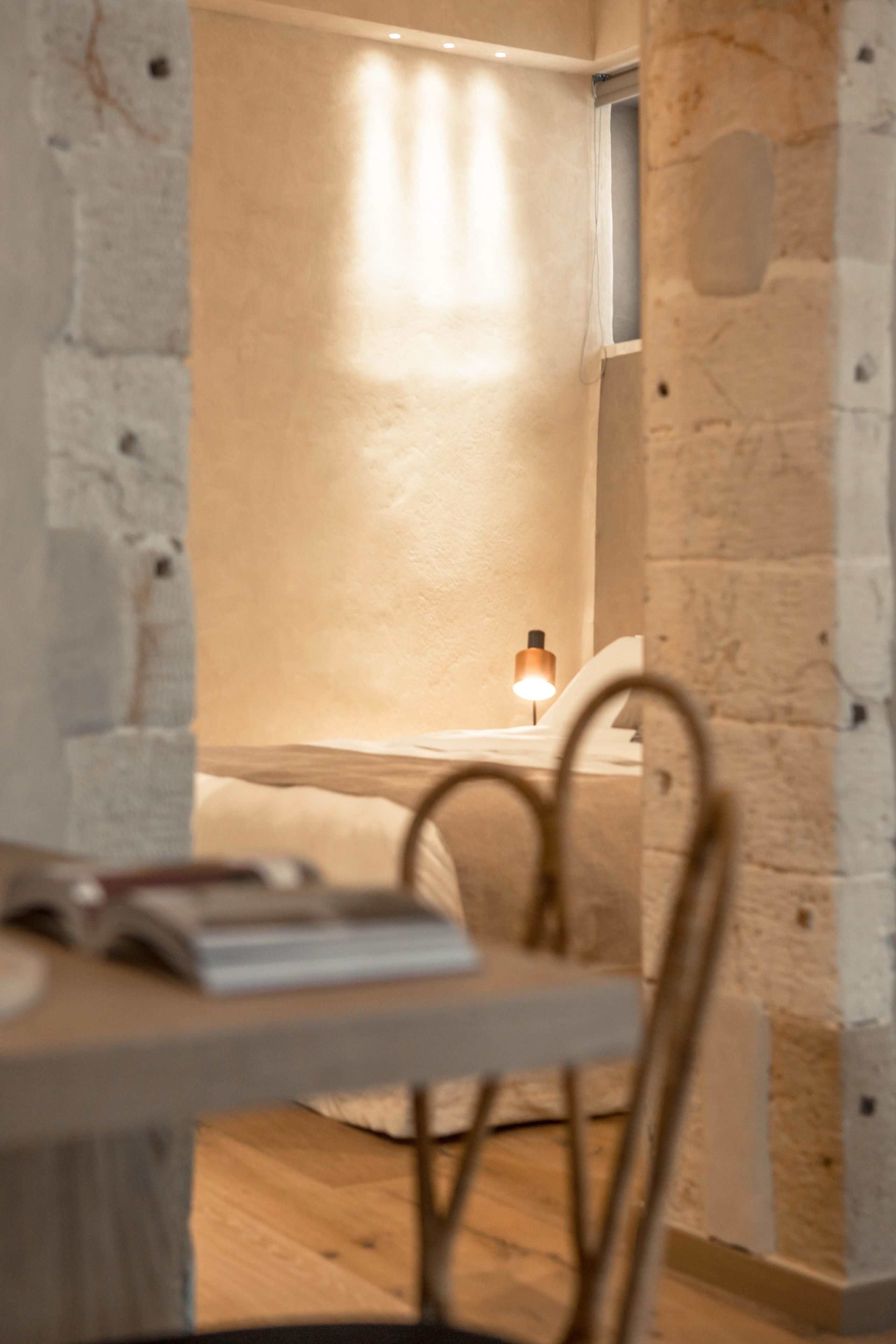 A room with a wooden table, a chair, and a lamp.