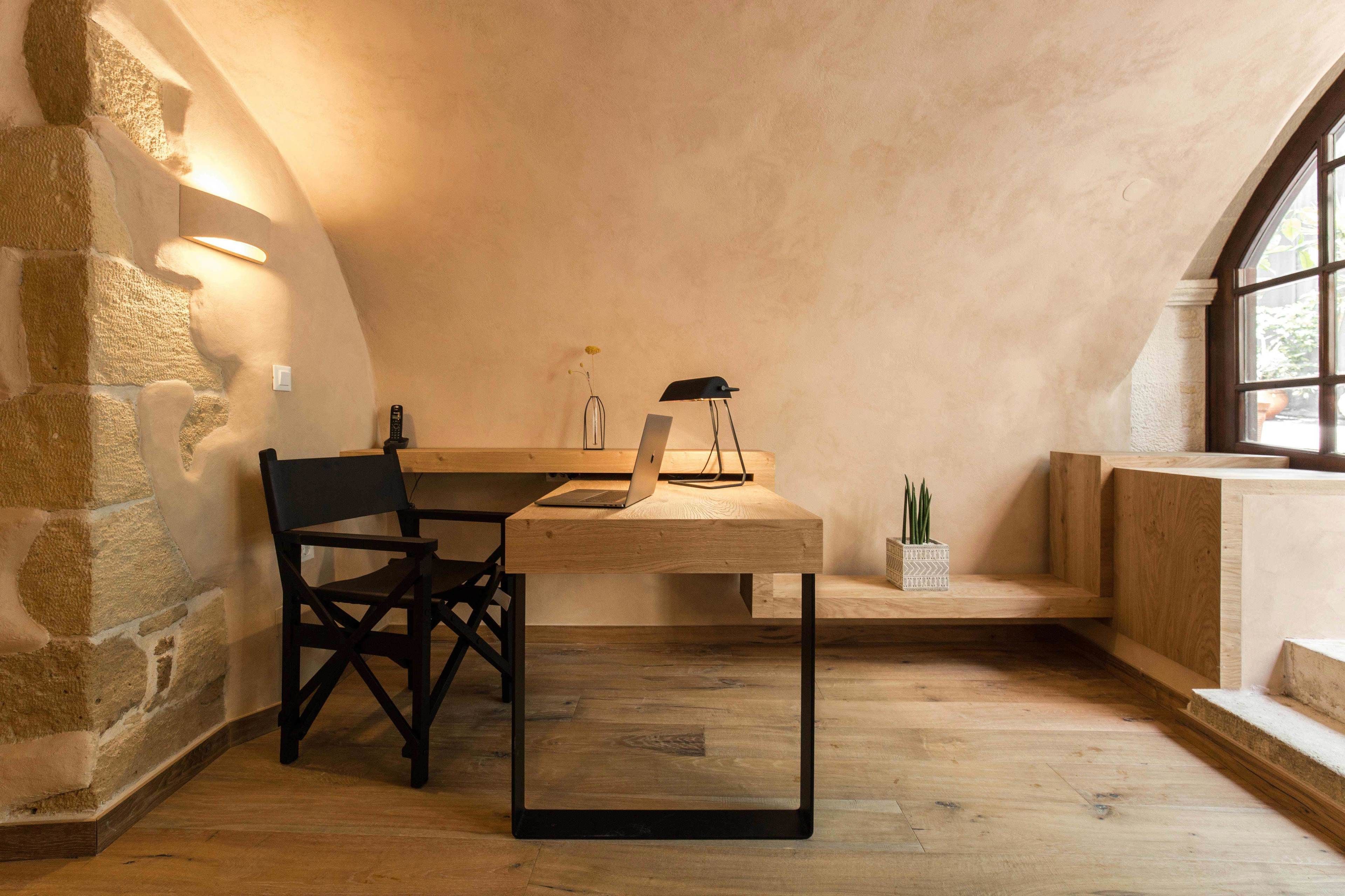A cozy workspace with a wooden desk, a chair, and a laptop.