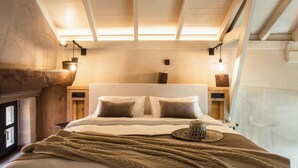 Une chambre confortable avec un grand lit, une tête de lit en bois et un panier tressé posé sur le lit.
