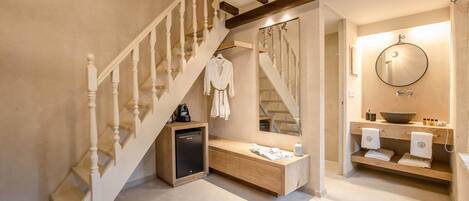 Une salle de bain moderne avec un meuble-lavabo en bois, un miroir rond et un lavabo encastré.
