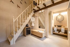 Une salle de bain moderne avec un meuble-lavabo en bois, un miroir rond et un lavabo encastré.