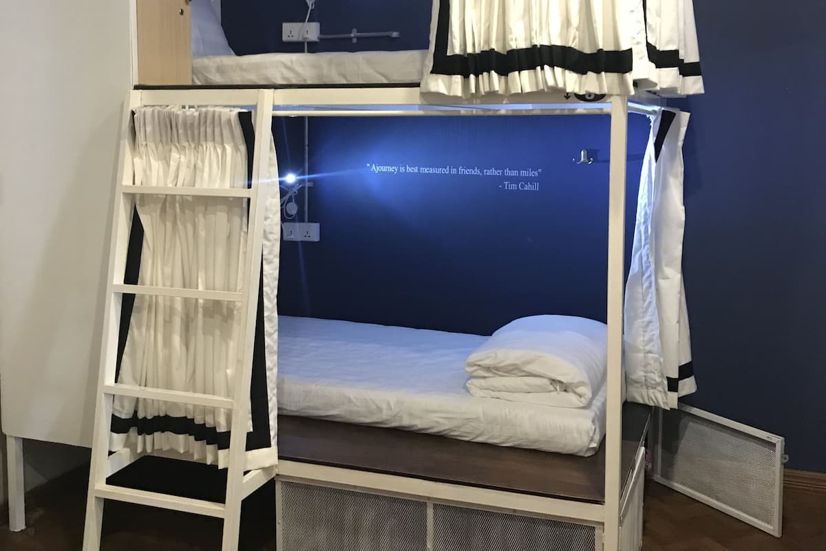 Een stapelbed met een ladder, bureau en stoel.