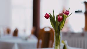 Et bord med en glassvase med lyserøde tulipaner.