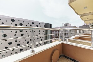 A rooftop terrace with a metal railing, a beige wall, and a patterned metal wall. - Apartamentos Maja (Benidorm)