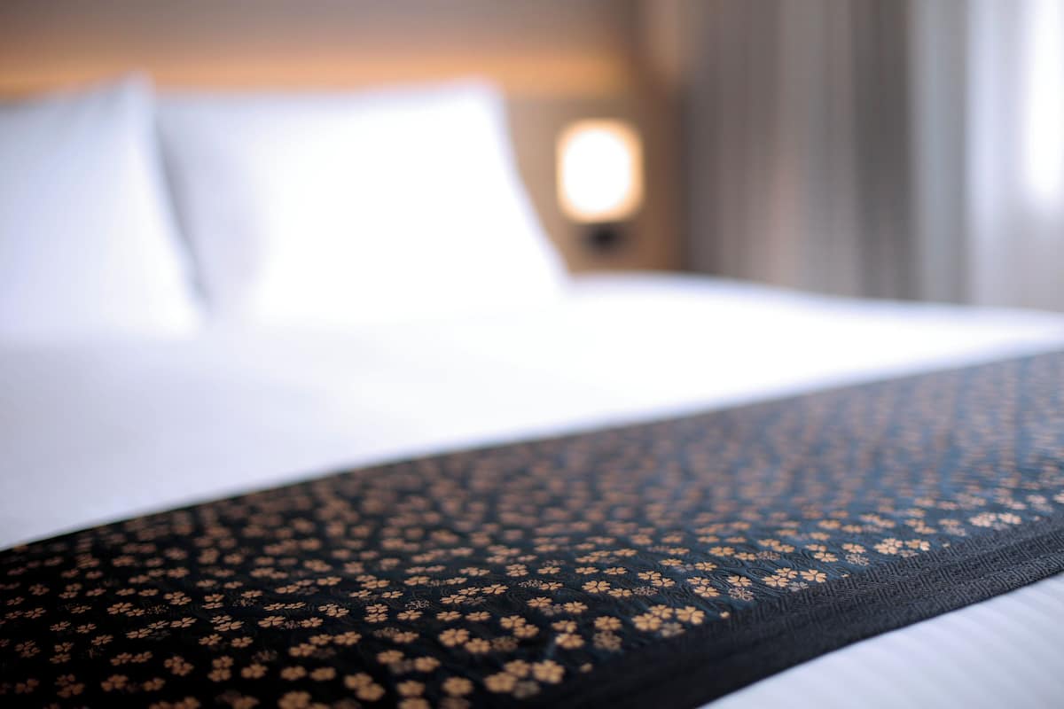 Una cama con una colcha de diseño negro y dorado.