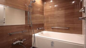 Ein modernes Badezimmer mit einer großen weißen Badewanne, einer Duschkabine aus Glas und Holzpaneelen an den Wänden.