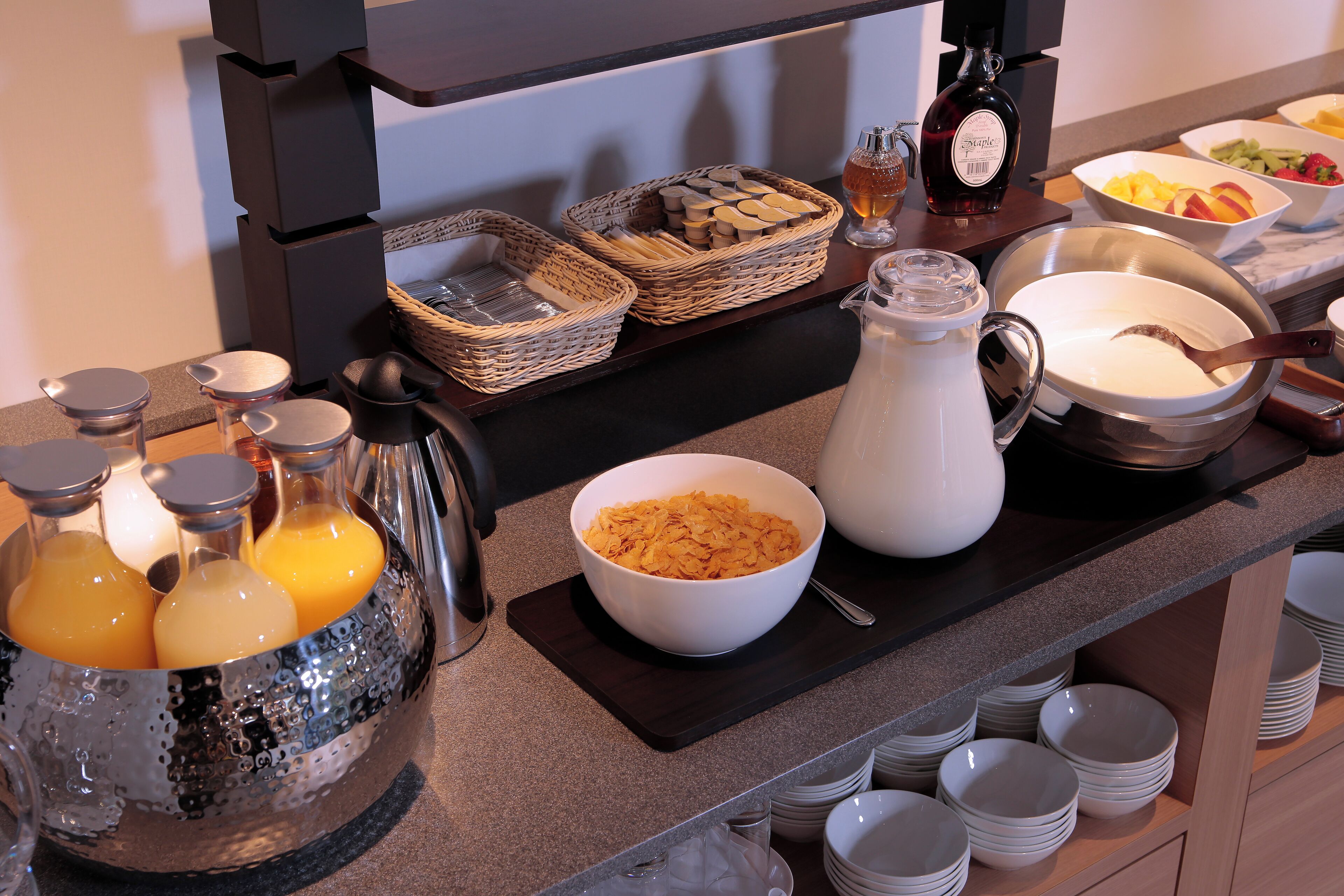 Un bufé de desayuno con diversos alimentos, bebidas y acompañamientos.