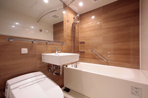 A modern bathroom with a bathtub, a sink, and a toilet.
