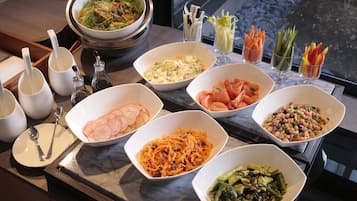 Una mesa de buffet con diferentes platos y utensilios.