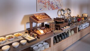 A buffet setup with various food items and serving ware.