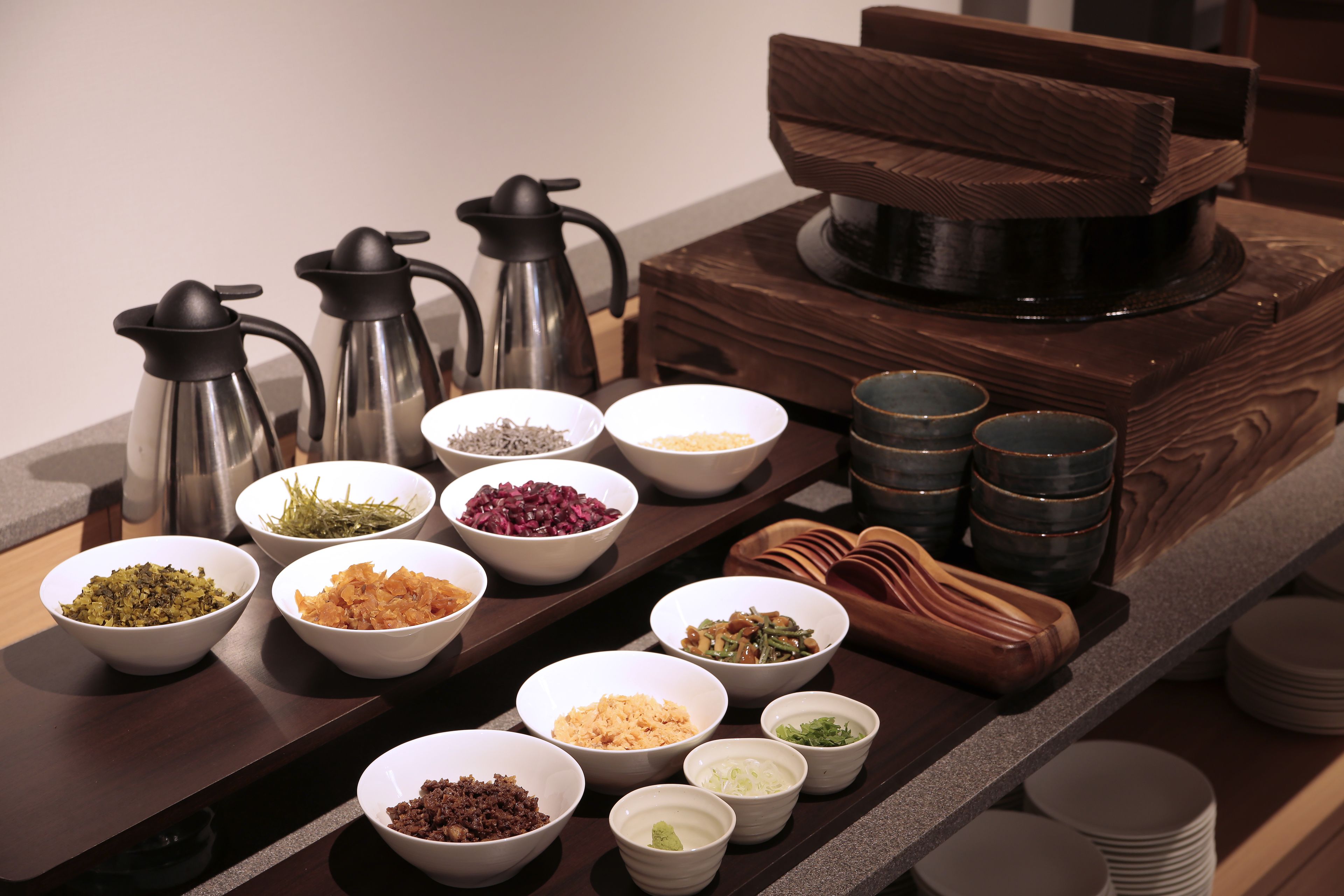 A buffet table with various food items and condiments.