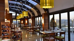Un restaurante de diseño moderno, con techo curvo y amplios ventanales que ofrecen vistas de la ciudad.