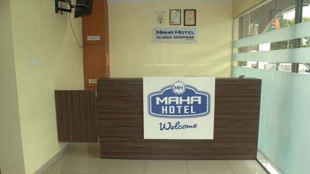 A reception desk with a sign reading "MAHA HOTEL Welcome". - Maha Hotel (Puchong)